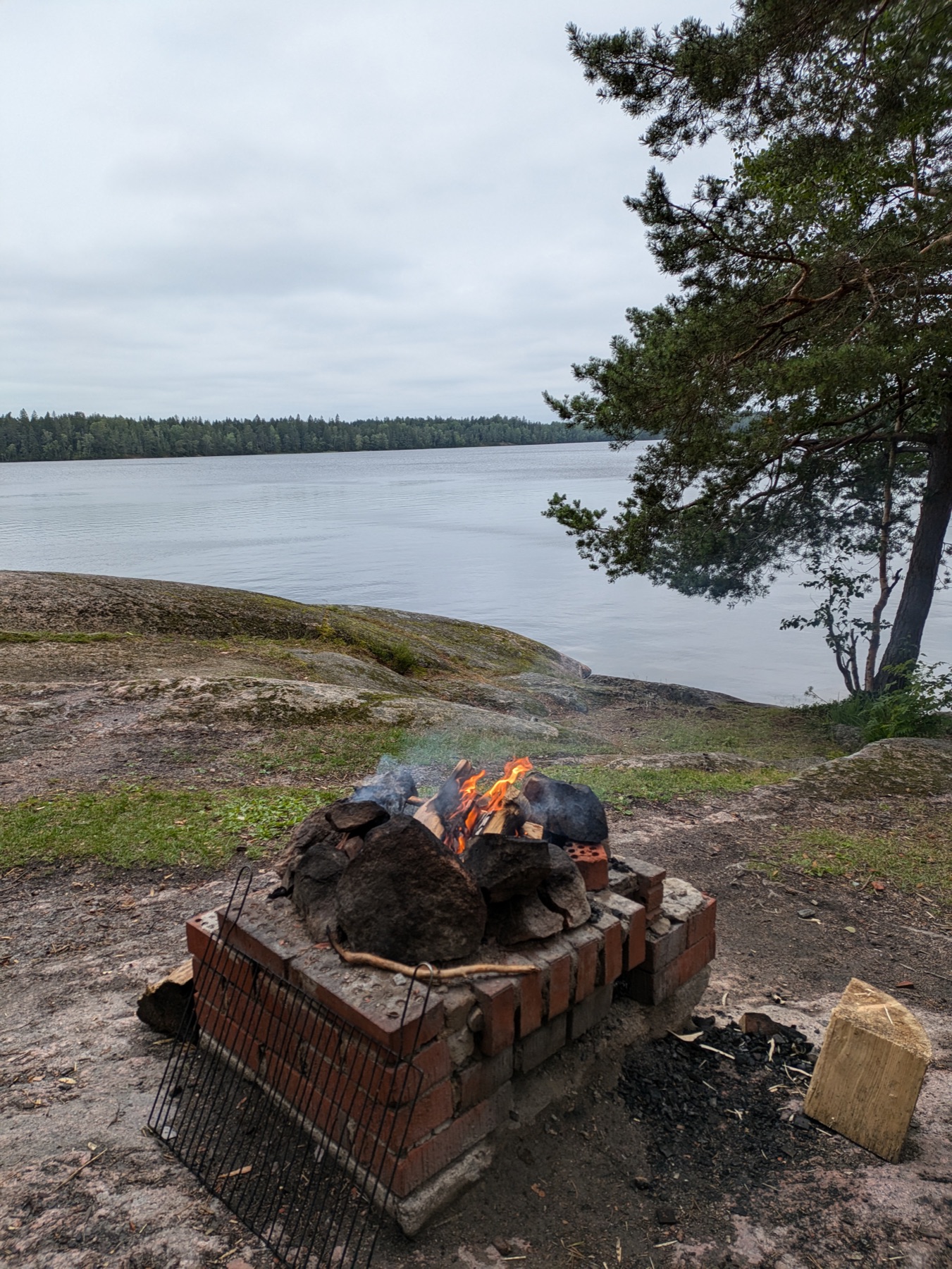 A campfire and coffee kettle by a Finnish forest lake
