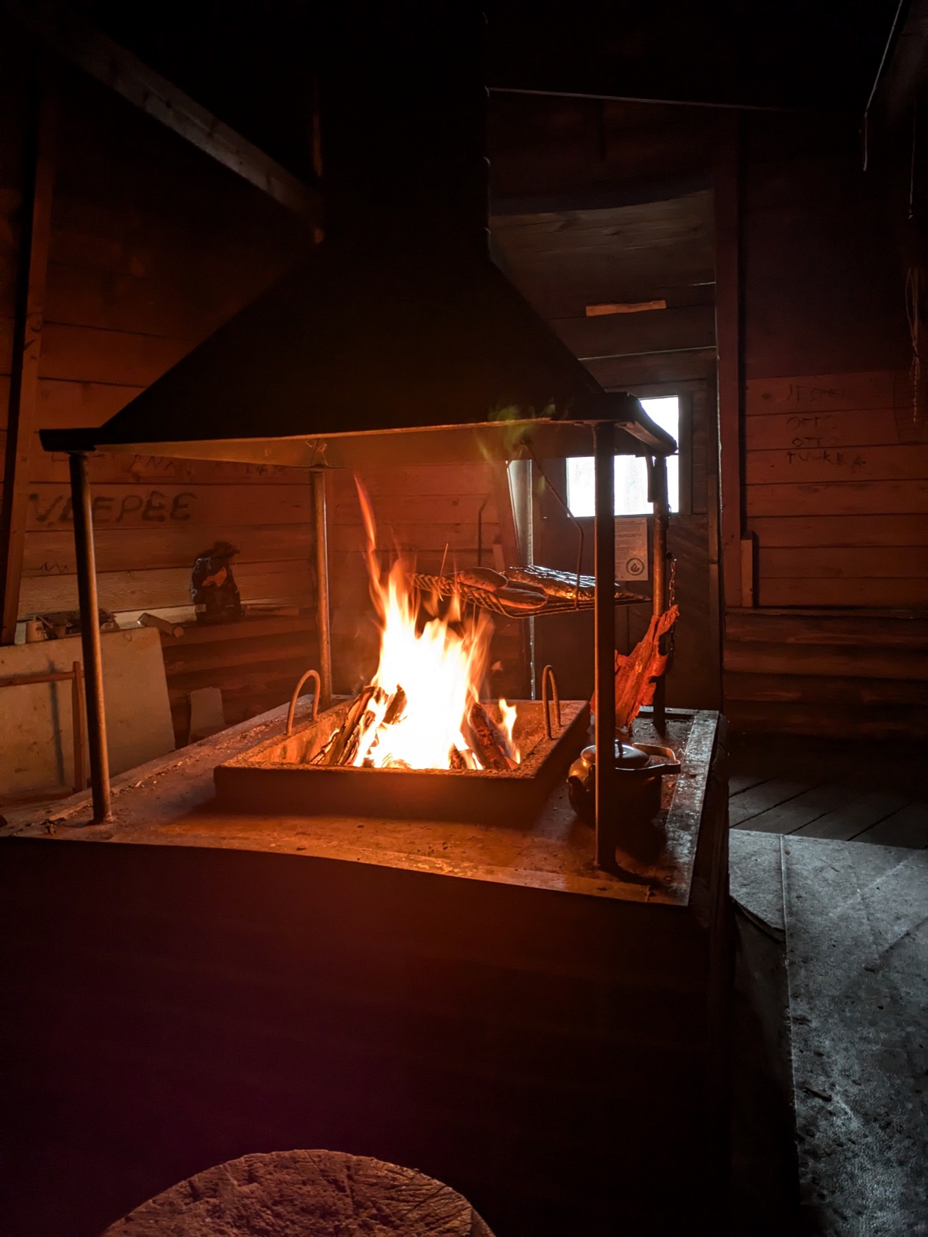 A warming open fire inside a wooden wilderness hut in winter
